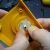 Pick two adjacent clips, and place firm pressure on them with your thumbnails. Remember to keep your fingers off the knob on the bottom side. Avoid using metal tools.